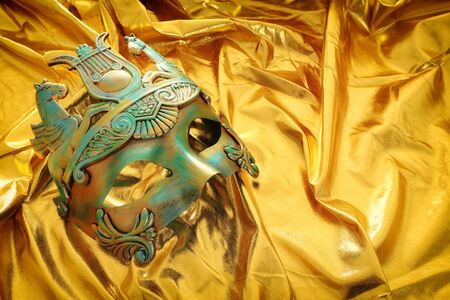 Photo of elegant and delicate Venetian mask over gold silk backgroundの写真素材