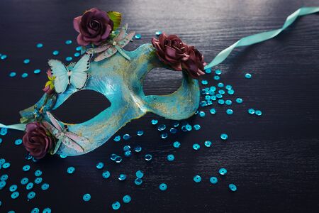 Photo of elegant and delicate blue Venetian mask over dark wooden backgroundの写真素材