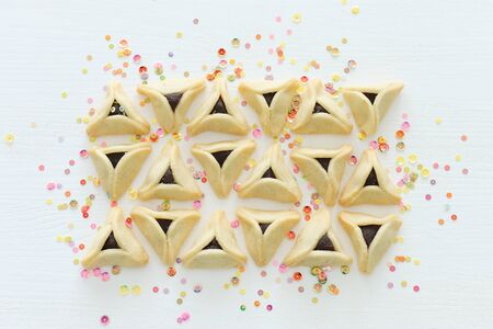 Purim celebration concept (jewish carnival holiday). Hamantaschen cookies over white wooden backgroundの写真素材