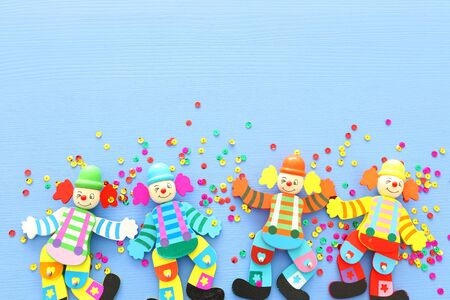 Party colorful noisemaker cute clown doll over blue wooden background . Top view, flat layの写真素材