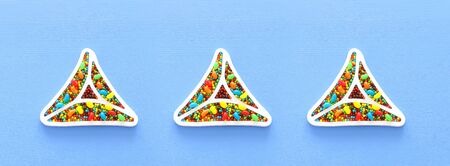 Purim celebration concept (jewish carnival holiday) over blue wooden background. Top view, Flat lay