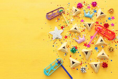 Purim celebration concept (jewish carnival holiday) over yellow wooden background. Top view, Flat layの写真素材