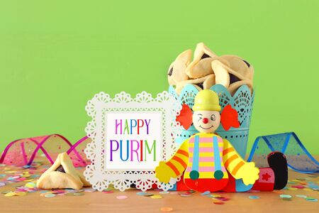 Purim celebration concept (jewish carnival holiday) over wooden table and green backgroundの写真素材