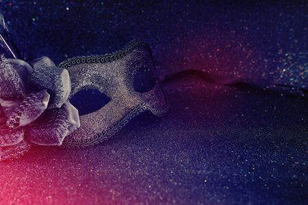 Photo of elegant and delicate black Venetian mask over dark glitter backgroundの写真素材