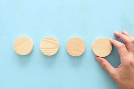 business concept of man hand arranging wooden round blocks. mock up or template