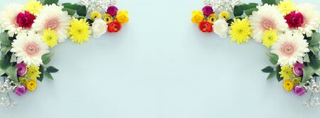 spring bouquet of buttercup colorful and white gerbera flowers over pastel wooden background. top...