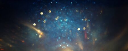 background of abstract glitter lights. gold, blue and black. de focused