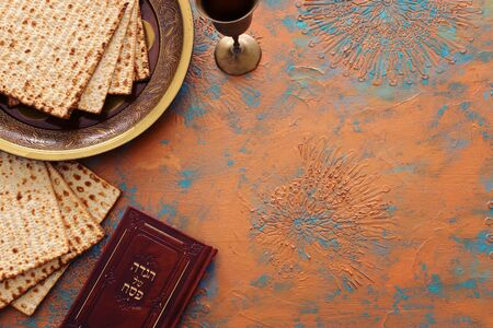 Pesah celebration concept (jewish Passover holiday). Traditional book with text in hebrew: Passover...