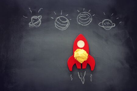 education or innovation concept. Wooden rocket over blackboard background. top viewの写真素材