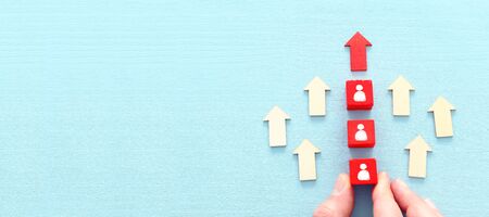 business image of wooden red cubes with people icons over wooden table , human resources and...