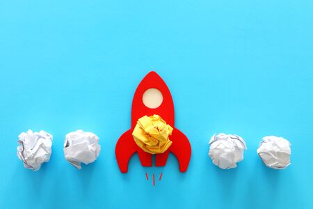 education or innovation concept. Wooden rocket over blue backgroundの写真素材