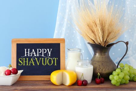 photo of dairy products over old wooden table and pastel background. Symbols of jewish holiday - Shavuotの写真素材