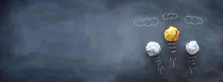 Education concept image. Creative idea and innovation. Crumpled paper as light bulb metaphor over blackboardの写真素材