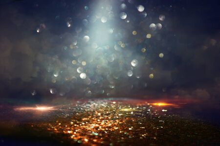 background of abstract glitter lights. gold and black. de focused
