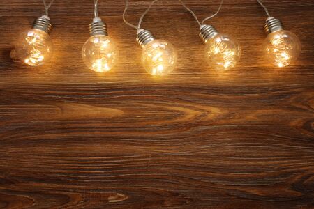 Light bulb lamps with warm light over old wooden backgroundの写真素材