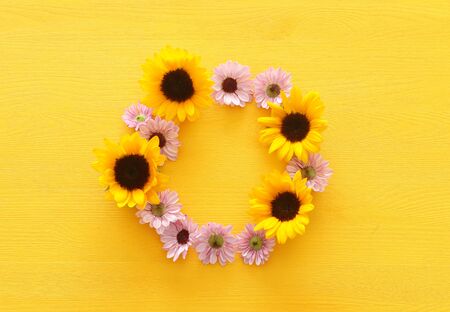 Top view image of sunflowers over yellow wooden backgroundの写真素材