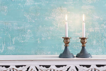 two shabbat candlesticks with burning candles over wooden tableの写真素材