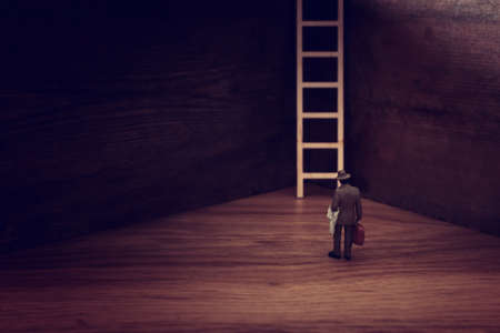 business concept picture of challenge. A man stands infront of a a ladder. Problem solving and decision making.の写真素材