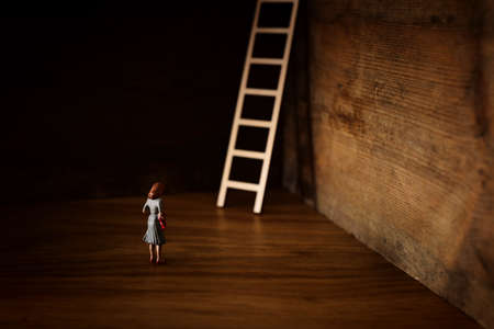 business concept picture of challenge. A woman stands infront of a a ladder. Problem solving and decision making.の写真素材