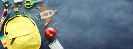 education. Back to school concept. rocket cut from paper and painted over blackboard background. top...