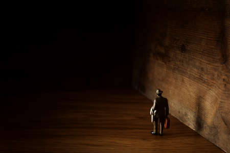 A concept image of a man who facing a dead end and has a wall in front of him. An idea of overcoming fear and obstaclesの写真素材