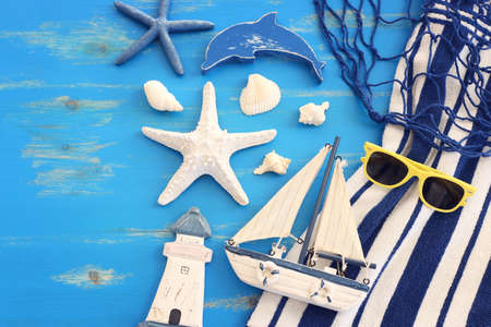 wooden vintage boat, dolphin, towel, boat and sea shells over blue backgroundの写真素材