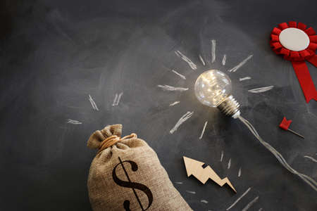 Concept image of lightbulb with coins stack. Innovate and money saving idea