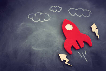 education or innovation concept. Wooden rocket over blackboard background. top view