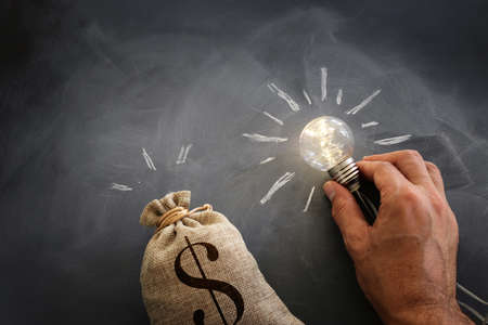 Concept image of lightbulb with coins stack. Innovate and money saving idea