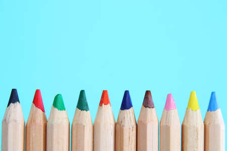 Row of colored wooden pencils over blue backgroundの写真素材