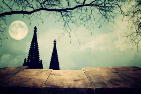 Halloween Holiday concept. Empty rustic table in front of scary night sky, forest and full moon...