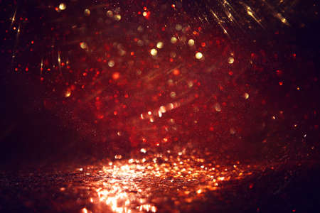background of abstract red, gold and black glitter lights. defocused