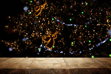 Empty table in front of christmas tree with decorations background. For product display montage