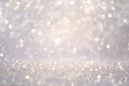 glitter vintage lights background. silver, gold and white. de-focused