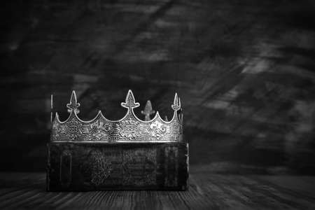 low key image of beautiful queen/king crown on old book. vintage filtered. fantasy medieval period....