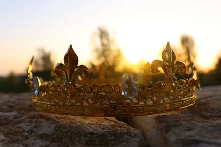 mysterious and magical photo of gold king crown in the England woods over stone. Medieval period concept.の写真素材