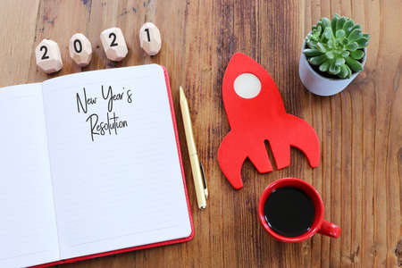 Business concept of top view 2021 goals list with notebook, cup of coffee over wooden deskの写真素材