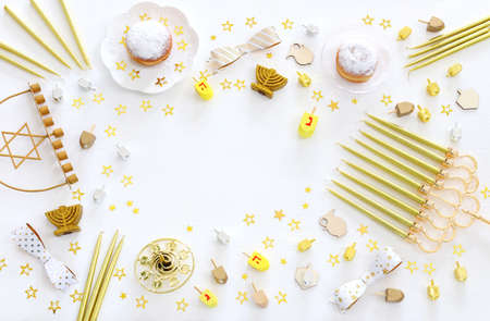 Image of jewish holiday Hanukkah with menorah (traditional Candelabra), donut and wooden dreidel...