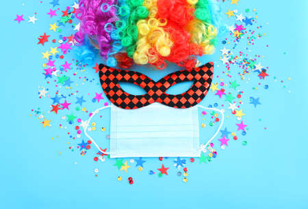 carnival, party and Purim celebration (jewish carnival holiday) over blue background. Coronavirus...