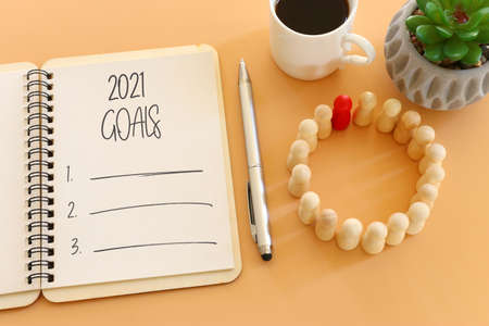 Business concept of top view 2021 goals list with notebook, cup of coffee over wooden deskの写真素材