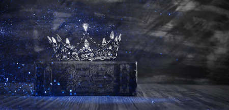 low key image of beautiful queen/king crown on old book. vintage filtered. fantasy medieval period....