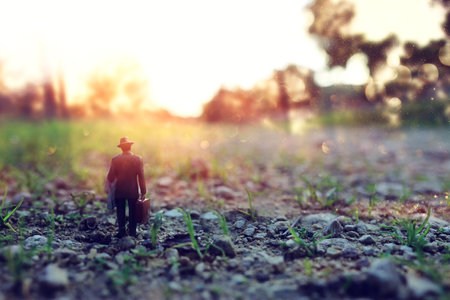 Surreal image of mysterious man walking alone in during sunsetの写真素材