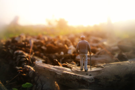 Surreal image of mysterious man walking alone in field during sunsetの写真素材