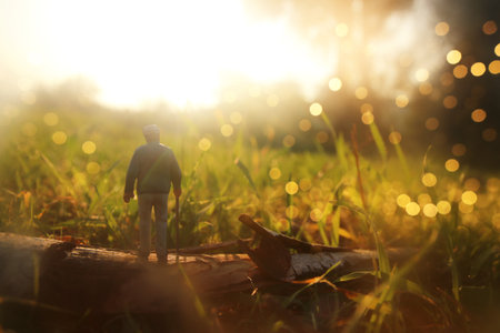 Surreal image of mysterious man walking alone in field during sunsetの写真素材