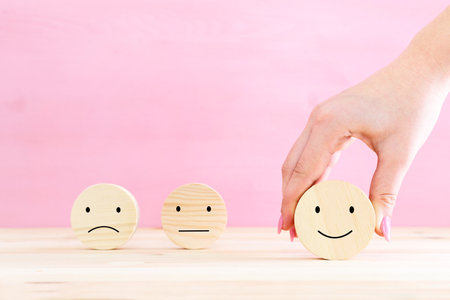 Concept image of satisfaction level. wooden circles with emotionsの写真素材