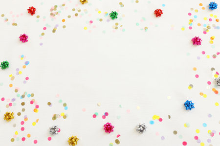 Party colorful confetti over white wooden background . Top view, flat layの写真素材