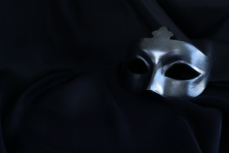 Photo of elegant and delicate Venetian mask over black silk backgroundの写真素材