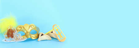 Purim celebration concept (jewish carnival holiday) over pastel blue background