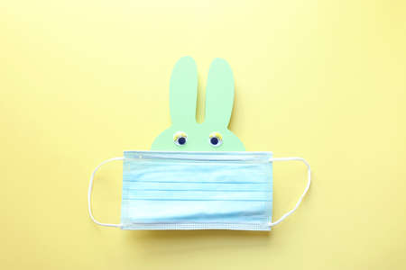Cute bunny with medical mask. Top view, Flat lay. Coronavirus prevention concept