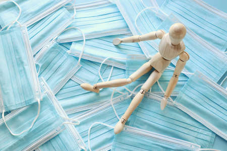 image of wooden dummy with worried stressed thoughts. over protective face mask background. anxiety and overloadの写真素材